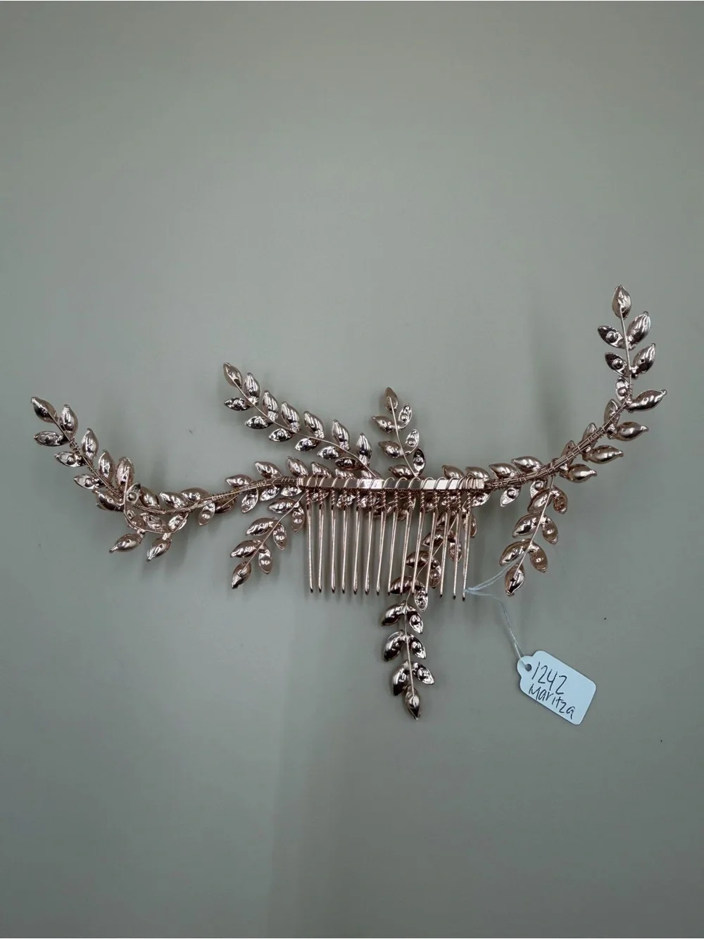 Elegant rose gold-tone bridal hair comb featuring a cascading leaf-and-vine desi